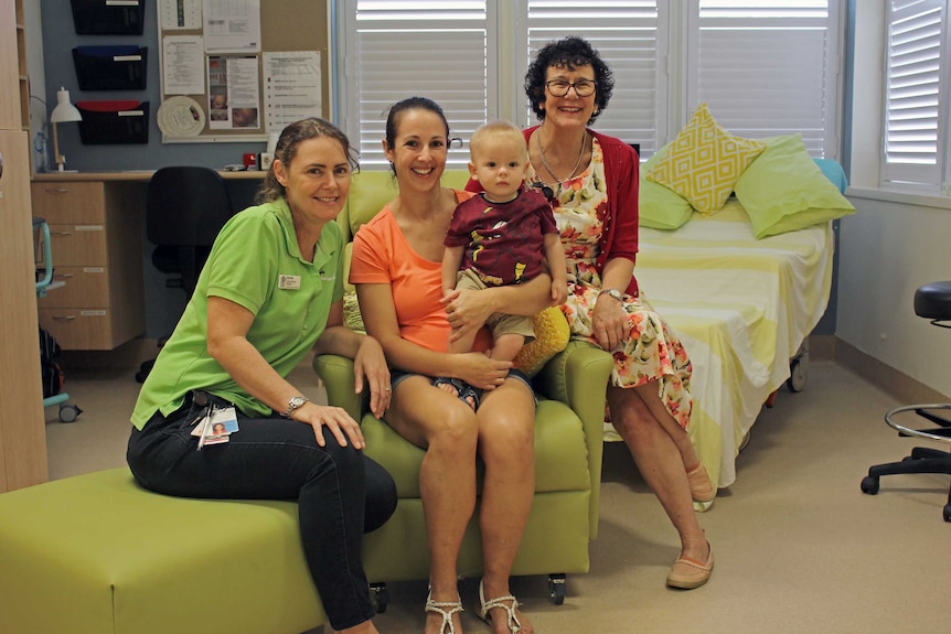 Ingham birthing service staff sit alongside a mum holding her one-year-old son inside the birthing room.