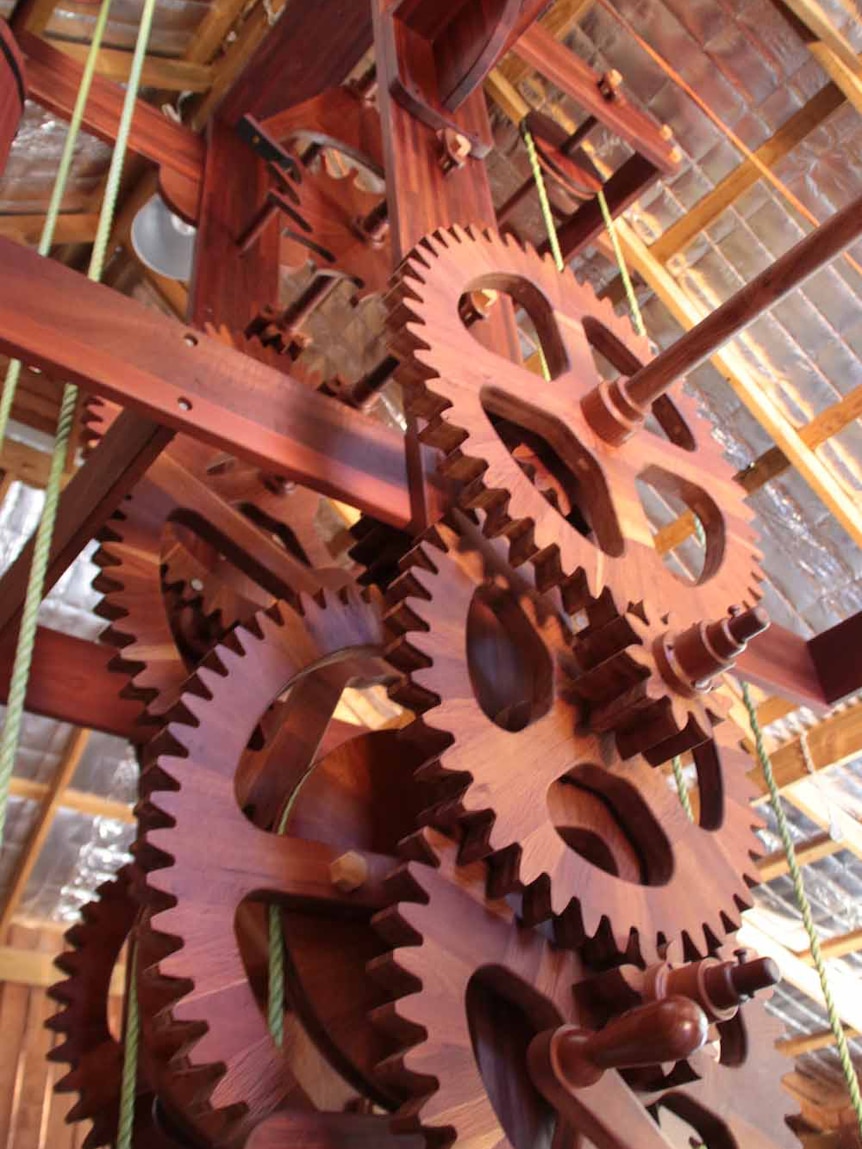 Large wooden cogwheels making up the mechanism of a pendulum clock