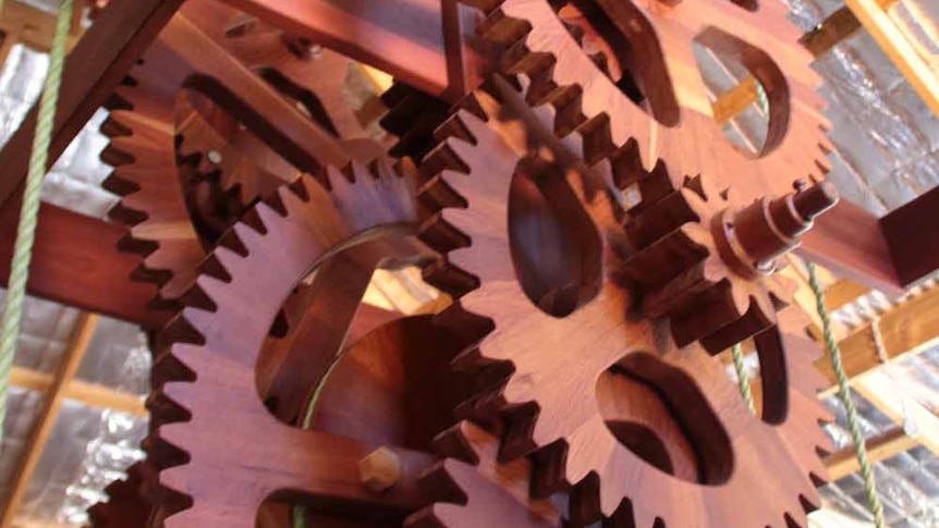 Large wooden cogwheels making up the mechanism of a pendulum clock