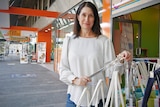 Townsville shop owner Lucy Downes stands outside her shop on Finders Street, the shop next to her is for lease