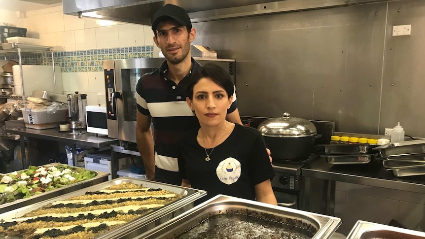 a couple in front of some Iranian food