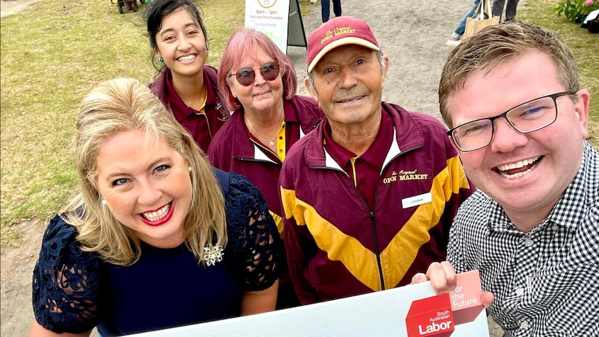 Three women and two men taking a selfie while holding up a sign of SA Labor Beach Road Revitalisation sign