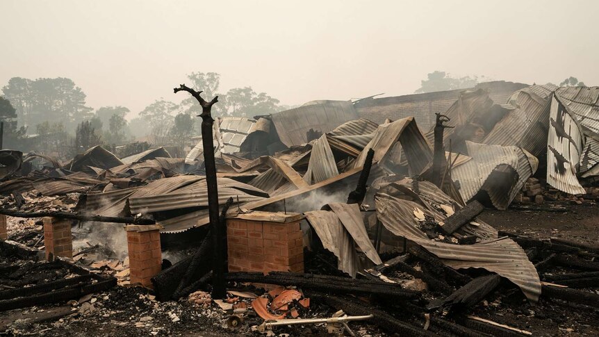 The ruins of a home destroyed by fire lies smouldering in Wingello.