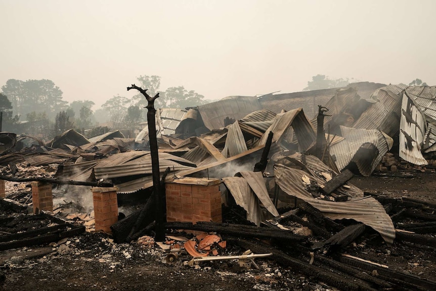 The ruins of a home destroyed by fire lies smouldering in Wingello.