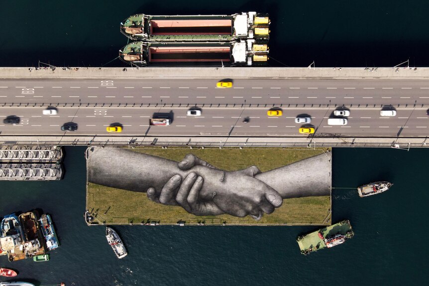 Una vista aérea muestra una obra de arte de manos entrelazadas en una barcaza flotante en Estambul, Turquía.