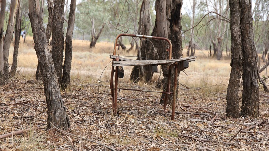 The remains of a rusted and falling apart chair in bushland