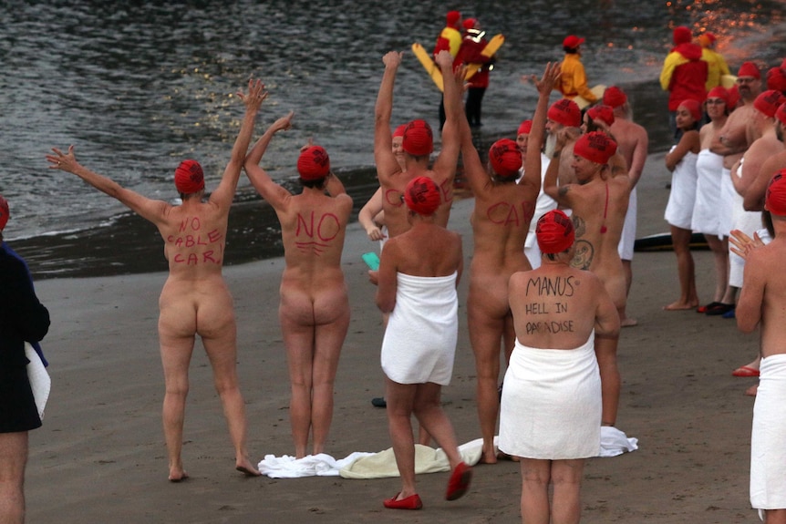 Political messages on swimmers' backs at Dark Mofo winter solstice nude swim.