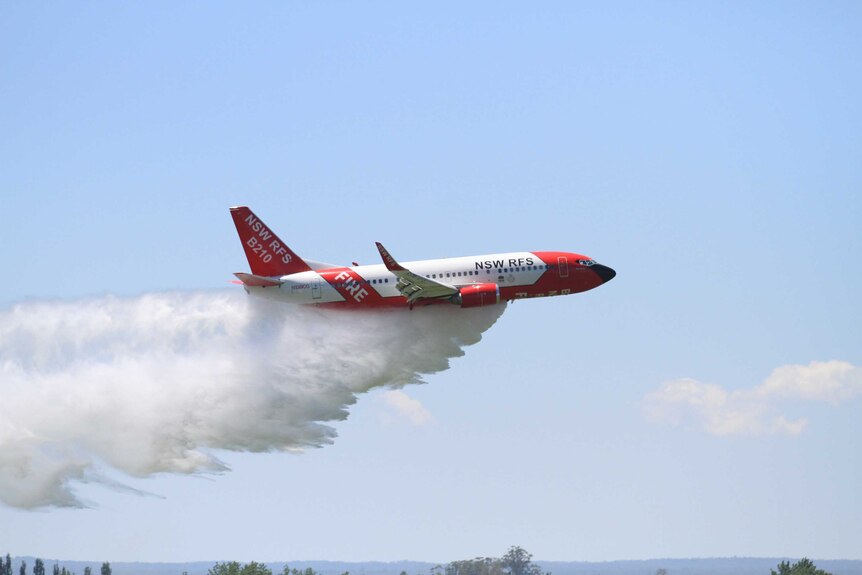 A plane dumping water to fight bushfires from the air.