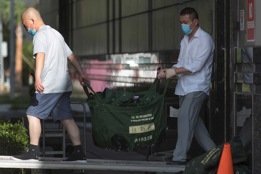 Consulate workers carry diplomatic bags from the Consulate General of China.