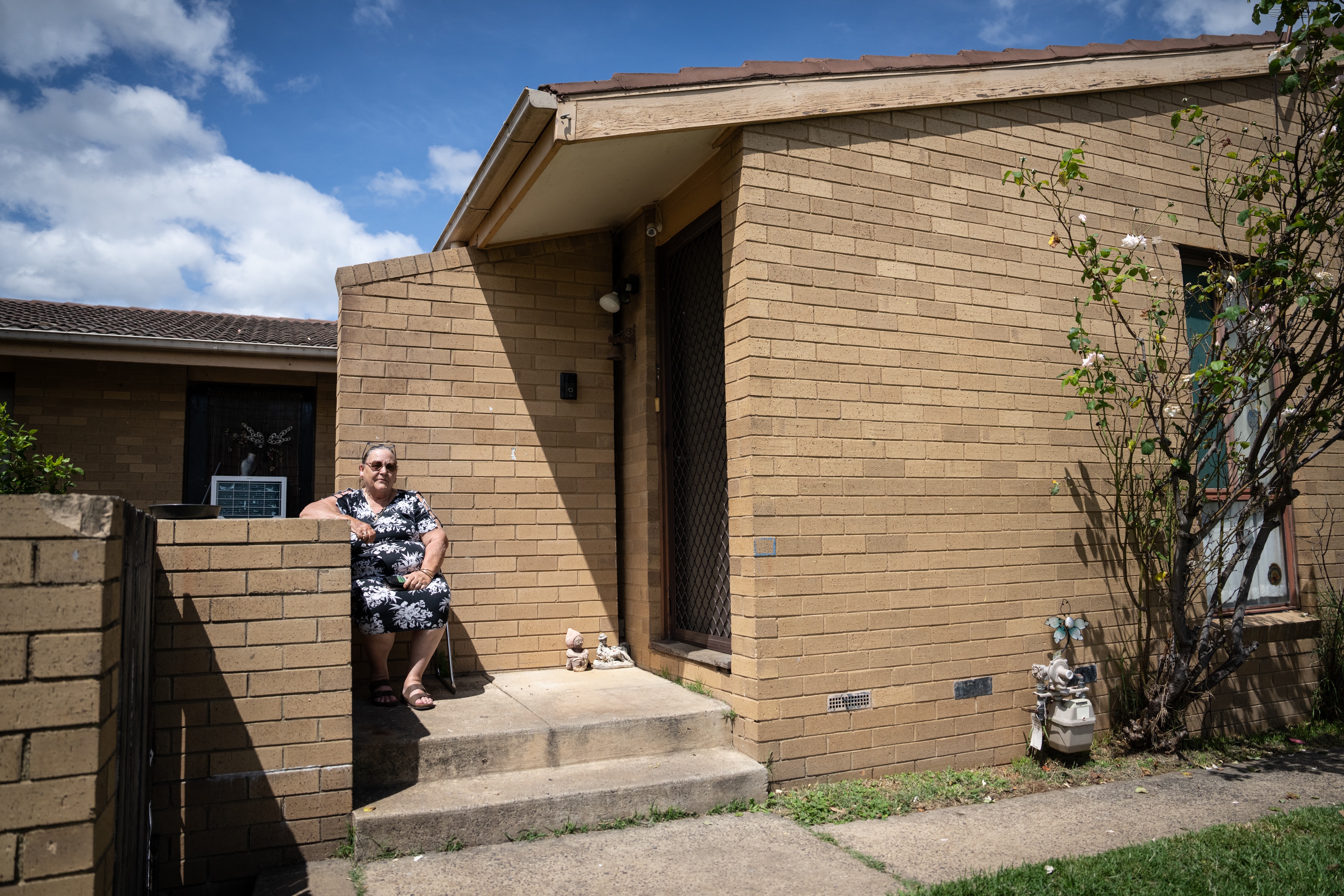 A woman sits on her front porch