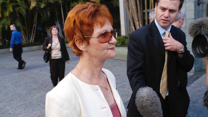Pauline Hanson's sister purses her ;lips as she speaks to media outside a Brisbane courthouse.