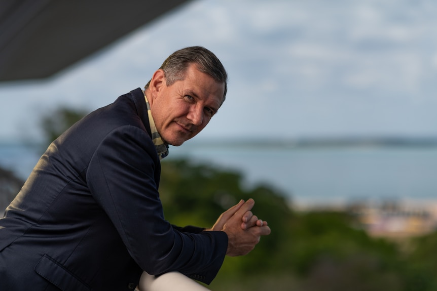 Former NT chief minister Michael Gunner glasping his hands and leaning on the balcony railing of NT Parliament House.