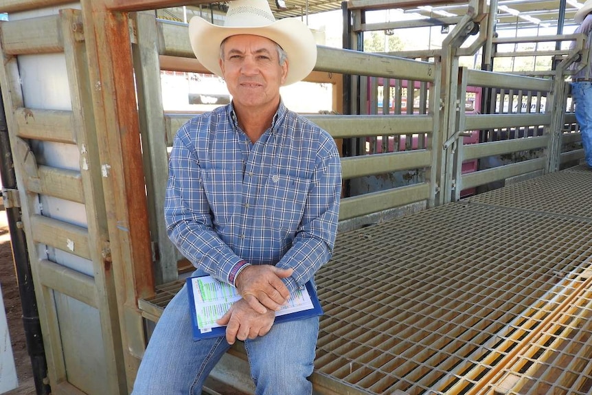 Man in big hat sits on grating