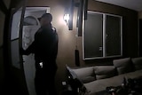 Police body-camera footage still shows police officer at the door of a home.