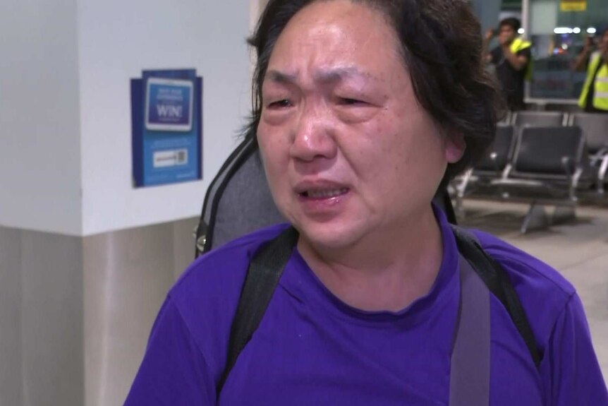 A woman cries in an airport.