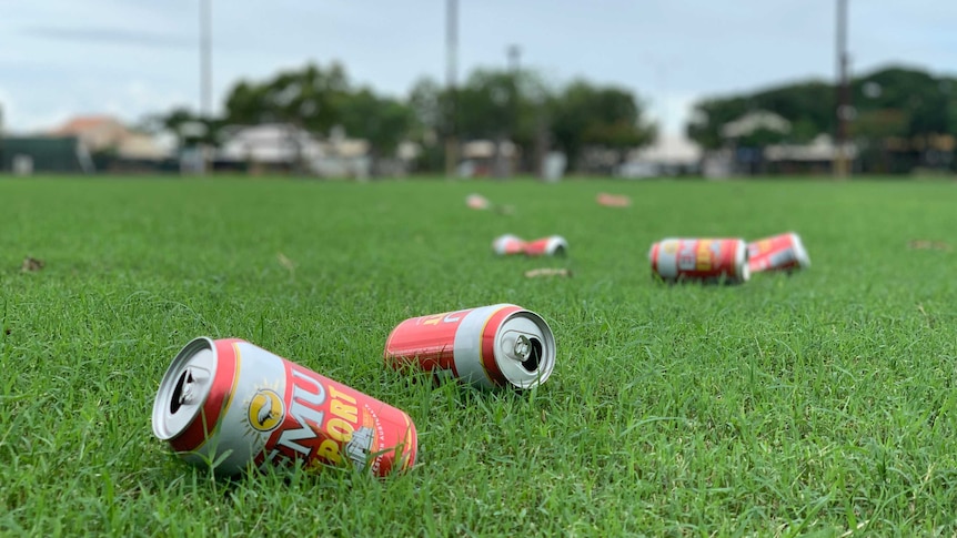 Image of multiple empty cans of beer that have been discarded on a sporting oval in Broome.