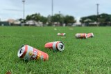 Discarded beer cans lying on a football oval.