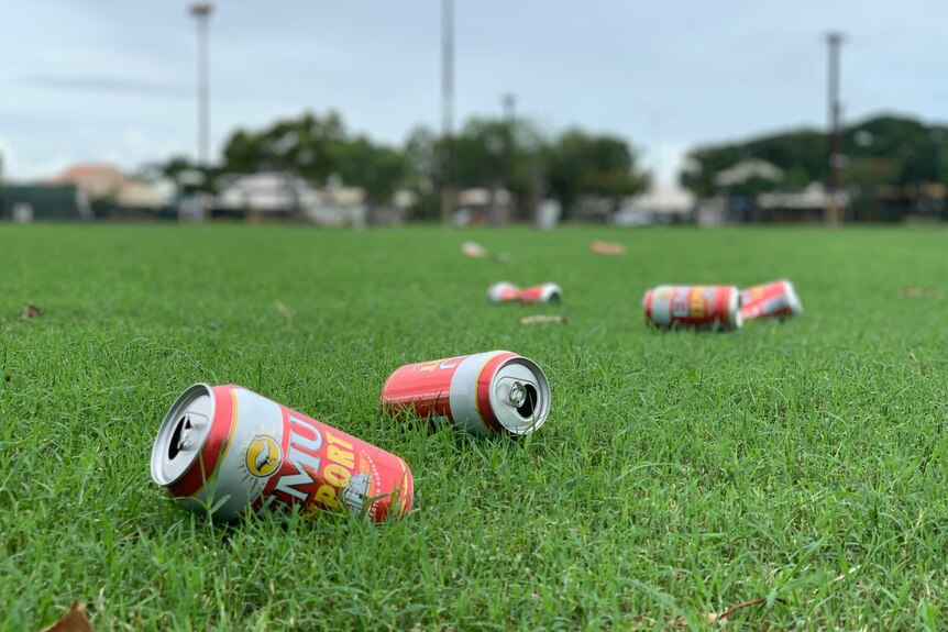 Image of multiple empty cans of beer that have been discarded on a sporting oval in Broome.