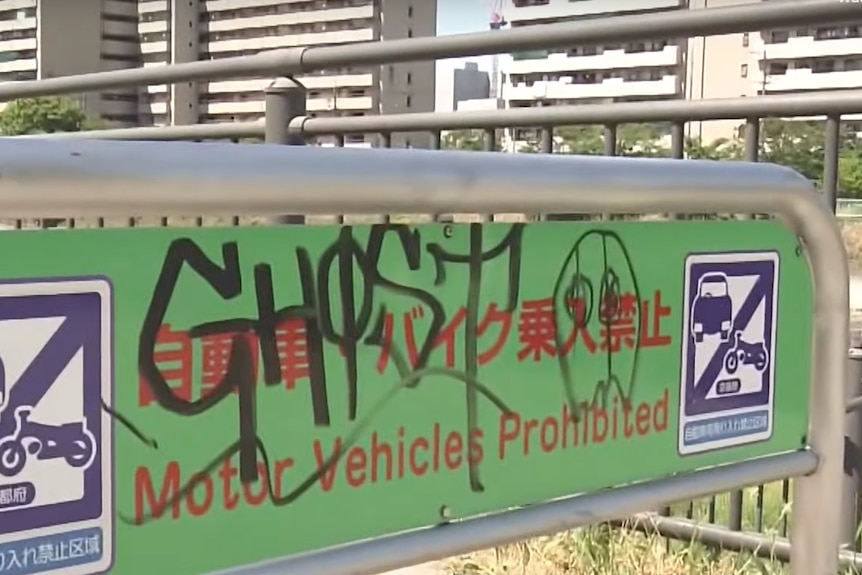 A parking sign with the graffiti tag "Ghost" scrawled across it