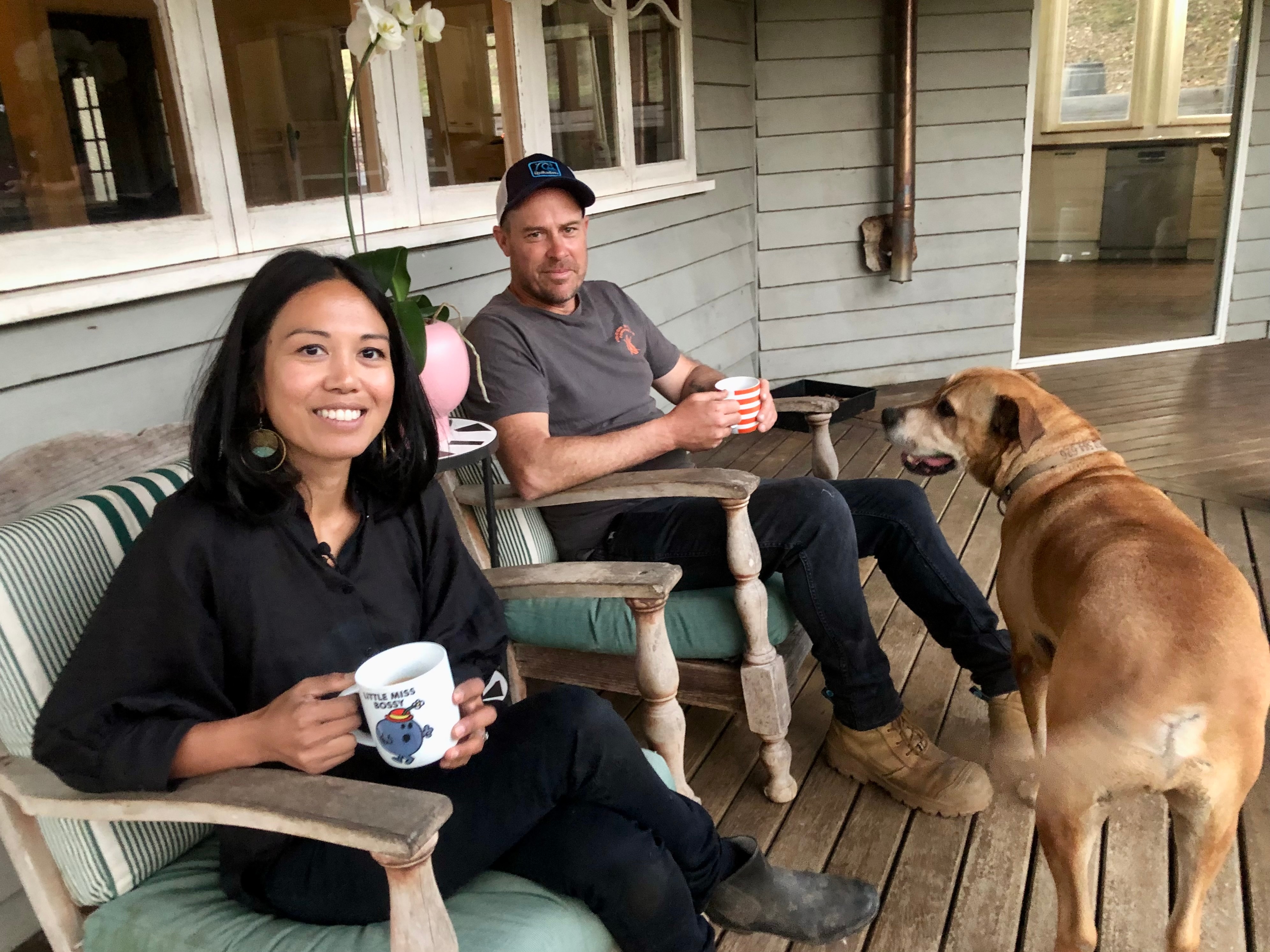 Having a cup of coffee with their dog on the verandah.
