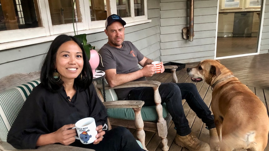 Having a cup of coffee with their dog on the verandah.