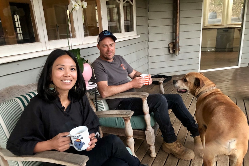 Having a cup of coffee with their dog on the verandah.