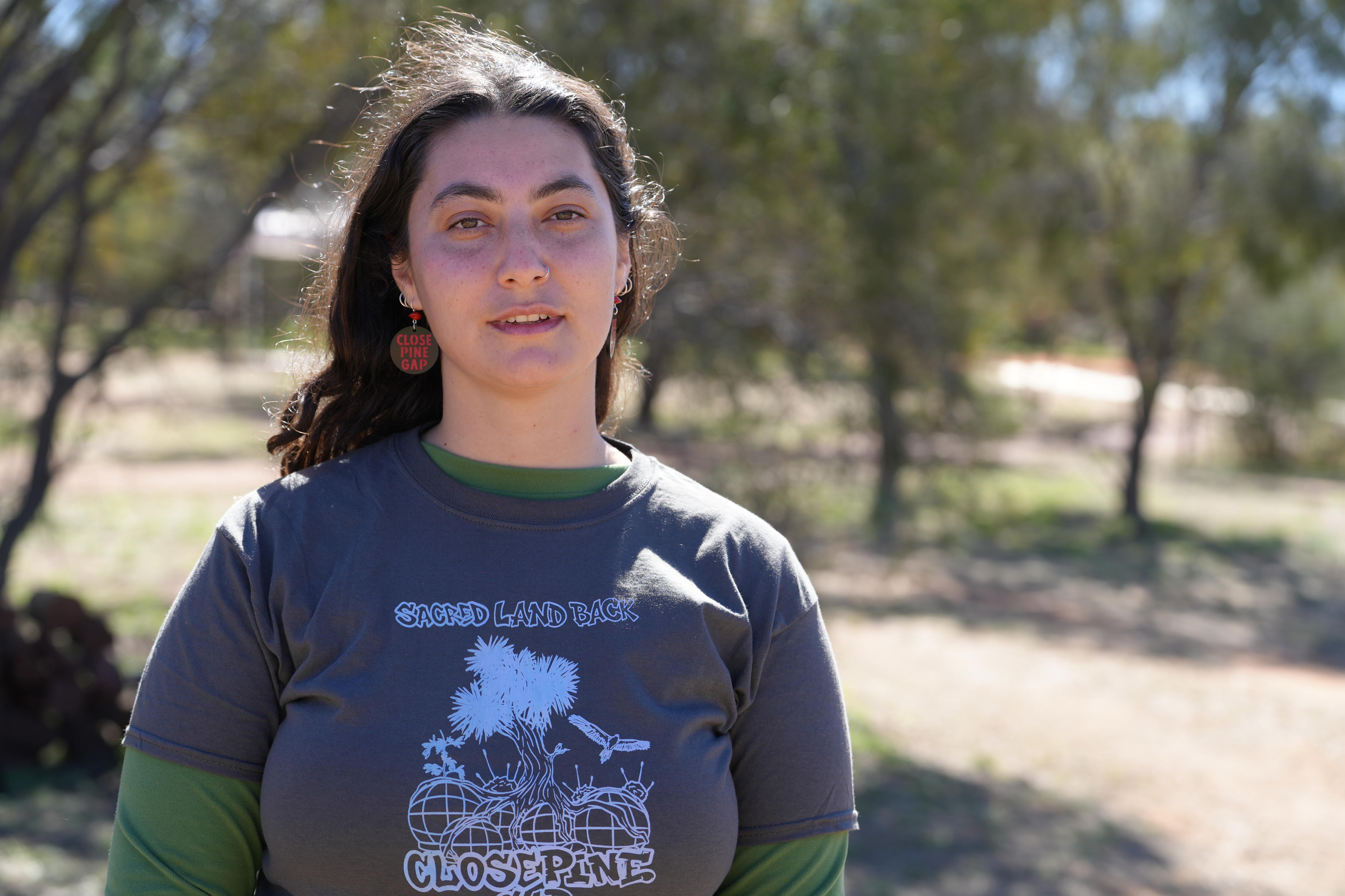 A young woman wearing a t shirt reading "close pine gap".