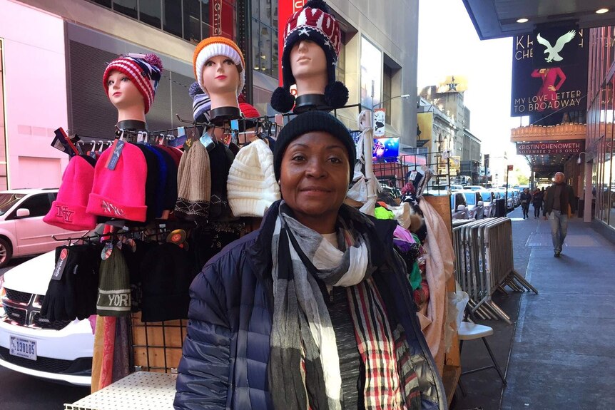 Hat-seller Ana Churrio stands with her goods on a street in New York.