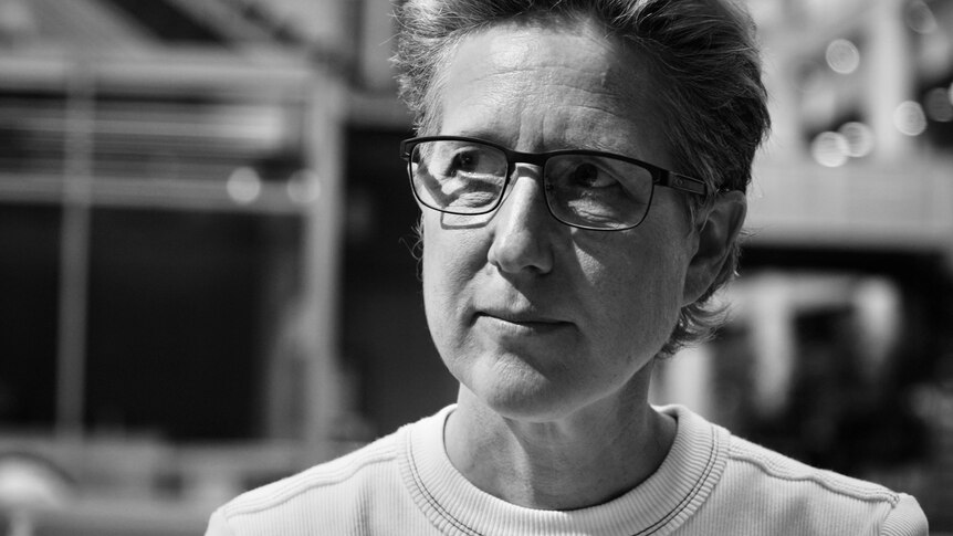 A black and white photo of a woman wearing glasses.