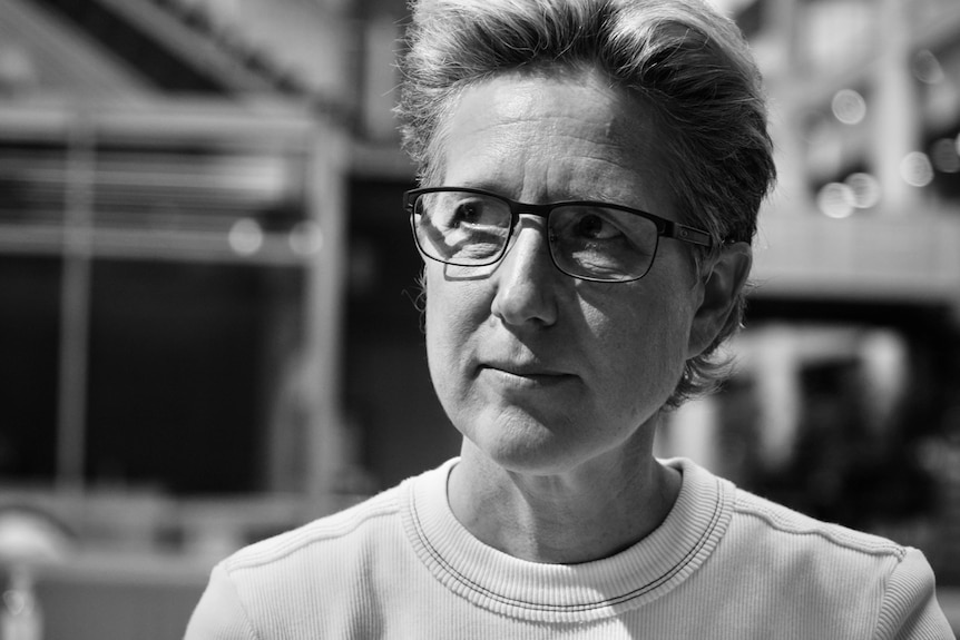 A black and white photo of a woman wearing glasses.