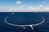 Two ships dragging a net.