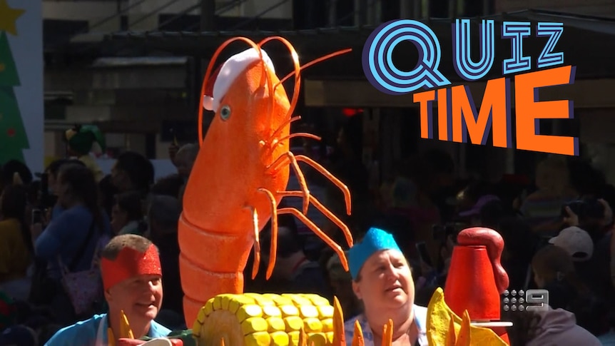 A large parade float shrimp wearing a santa claus hat. 