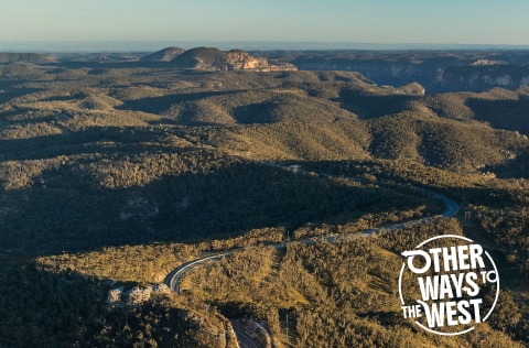 Landscape shot of winding road with 'other ways to the west' written in the bottom right corner
