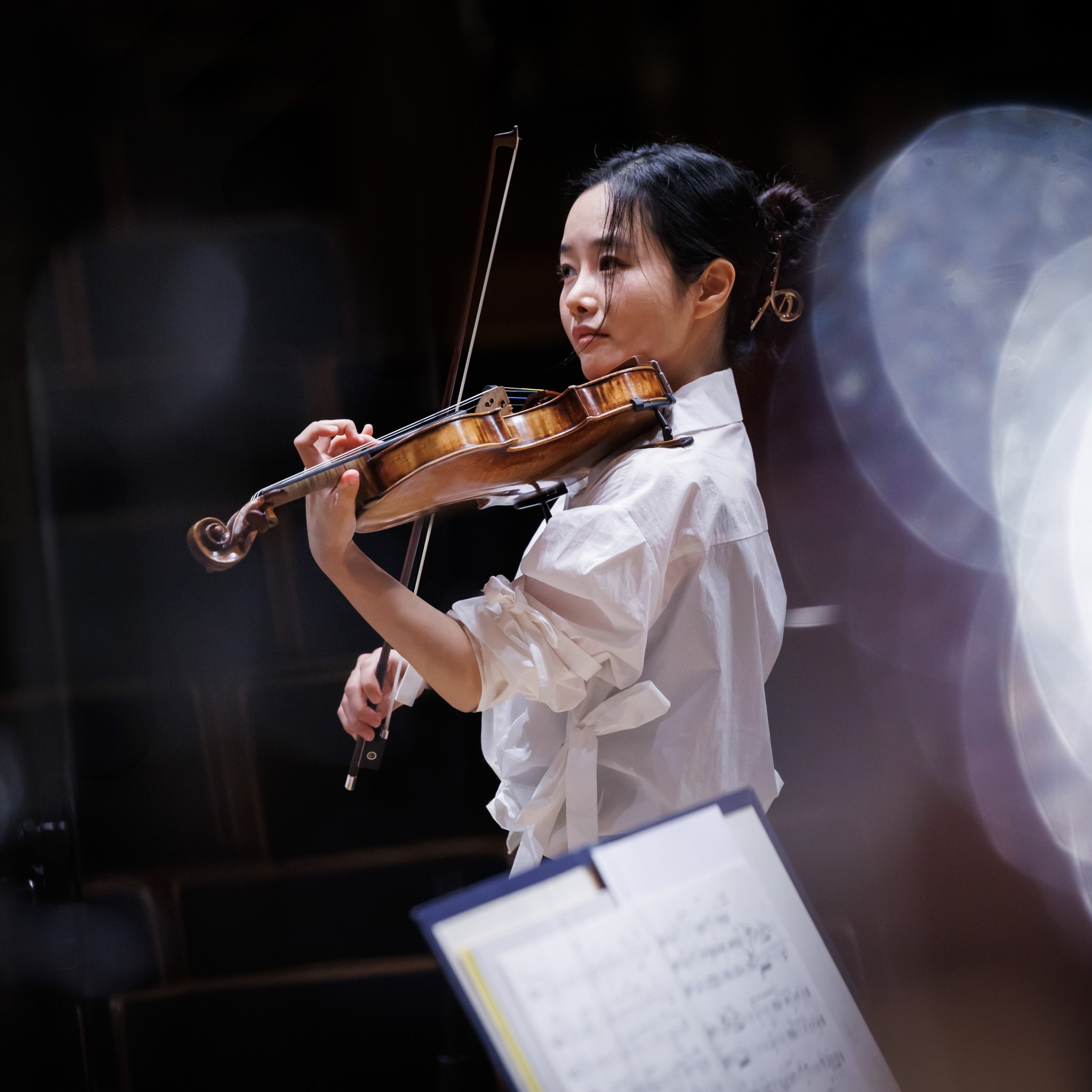 Violinist Bomsori Kim wearing a white shirt and playing her violin.