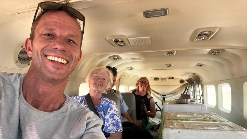 Four people pose for a selfie inside a plane at Newman airport. 
