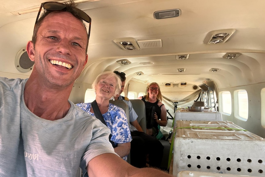 Four people pose for a selfie inside a plane at Newman airport. 