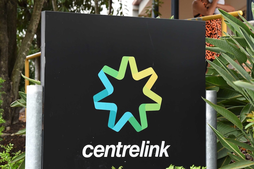 Woman nurses baby outside Centrelink