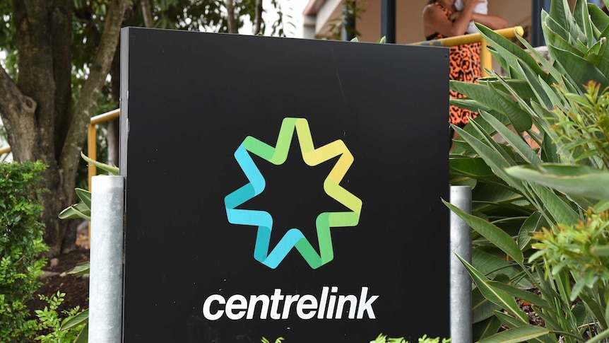 Woman nurses baby outside Centrelink