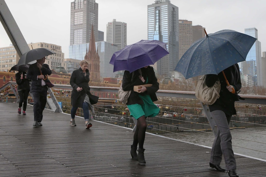 People with umbrellas walking in central Melbourne.