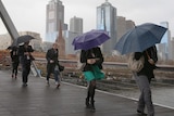 People try to shelter from the rain in Melbourne.