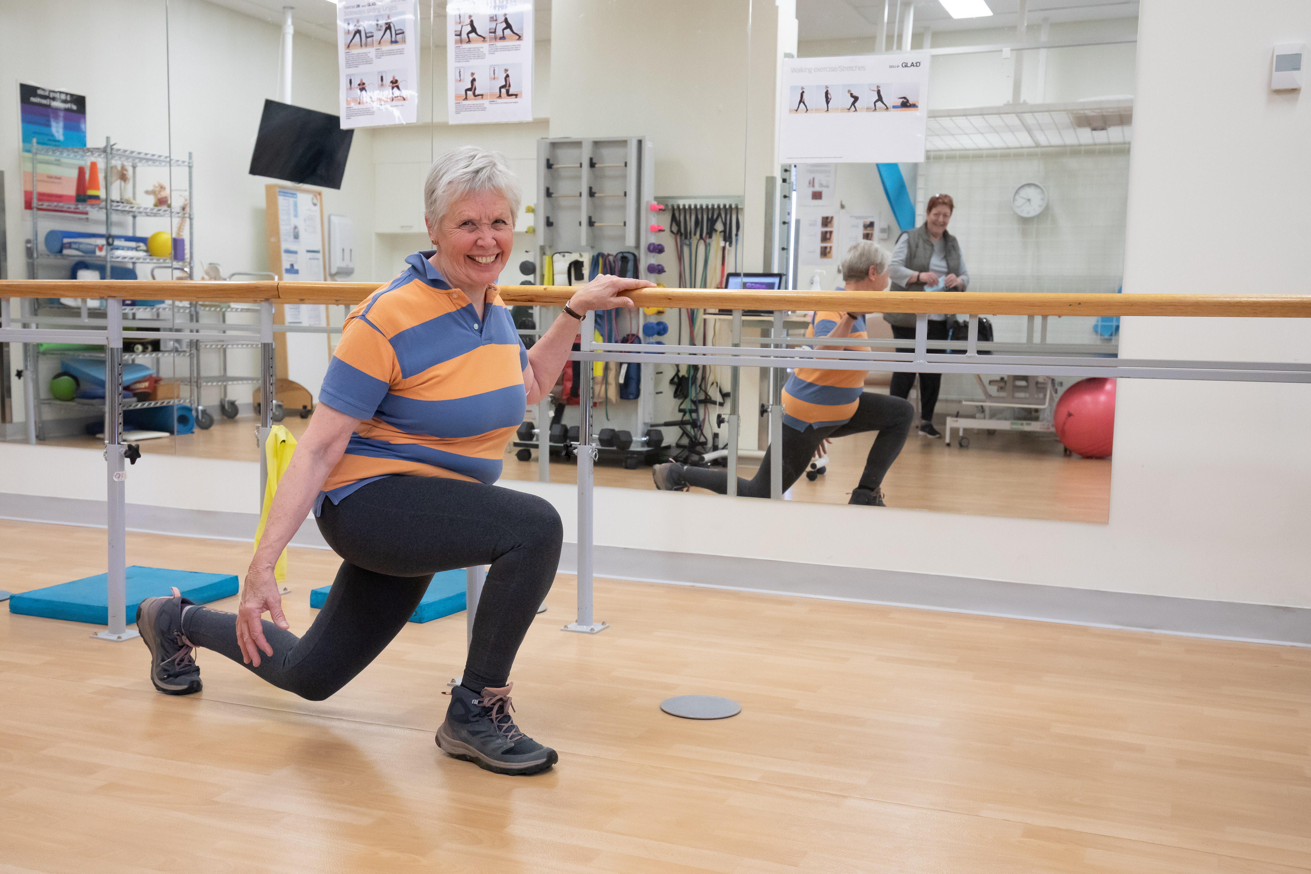 A woman lunges in a rehabilitation space.