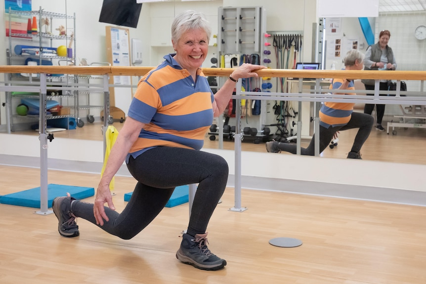 A woman lunges in a rehabilitation space.