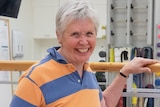 A woman lunges in a rehabilitation space.