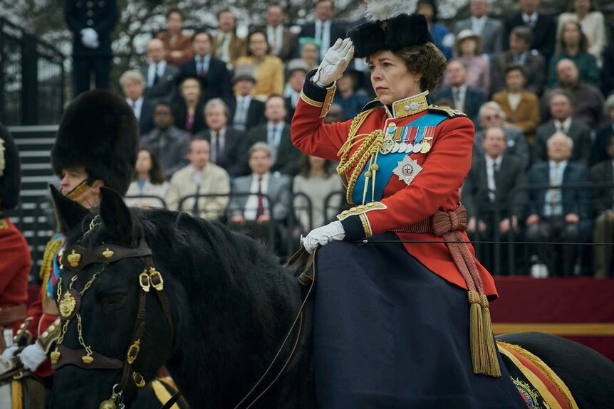 An actress playing Queen Elizabeth salutes from atop a horse