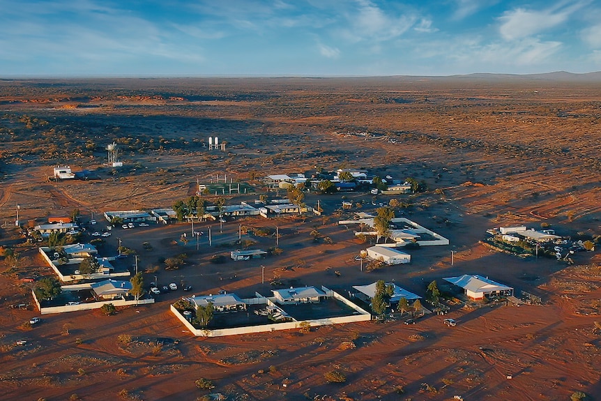 An aerial shot of remote buildings in red dirt
