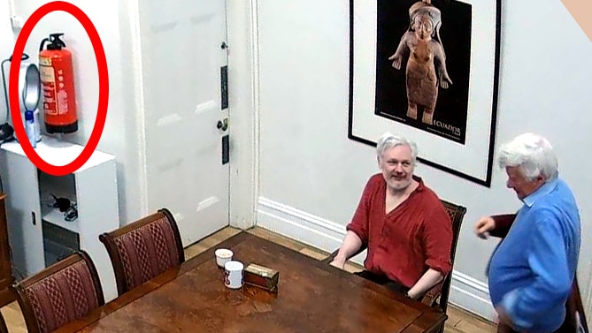 Assange and Robertson sit at a meeting table.