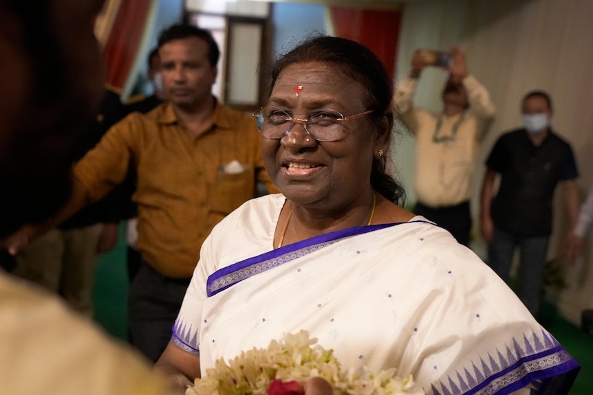 India's newly president elect Droupadi Murmu greets the crowd gathered at her temporary residence in New Delhi.