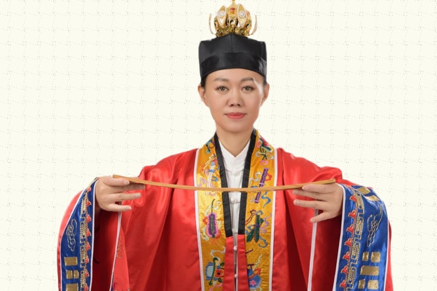A woman wearing a Chinese Taoism costume looks ahead