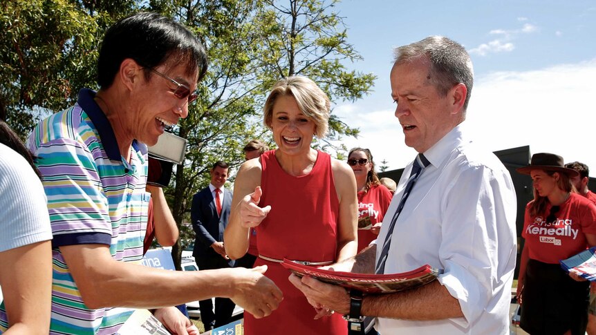 Bill Shorten, right, and Kristina Keneally meet with a voter at a polling booth.