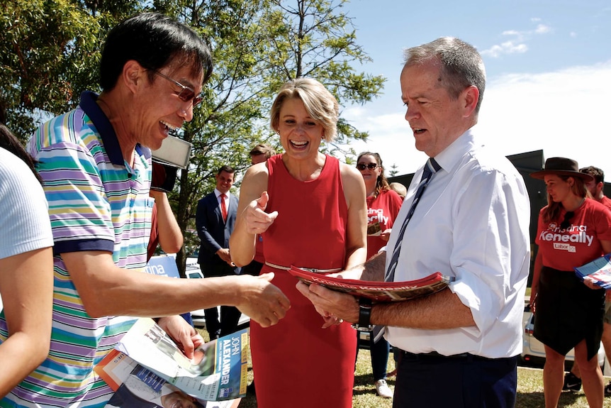 Bill Shorten, right, and Kristina Keneally meet with a voter at a polling booth.